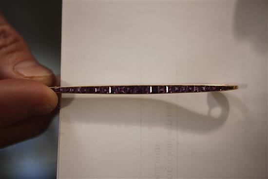 A Cartier amethyst and 18ct gold bar brooch, channel-set with 29 square-cut rubies, signed Cartier, Paris numbered 3056?,